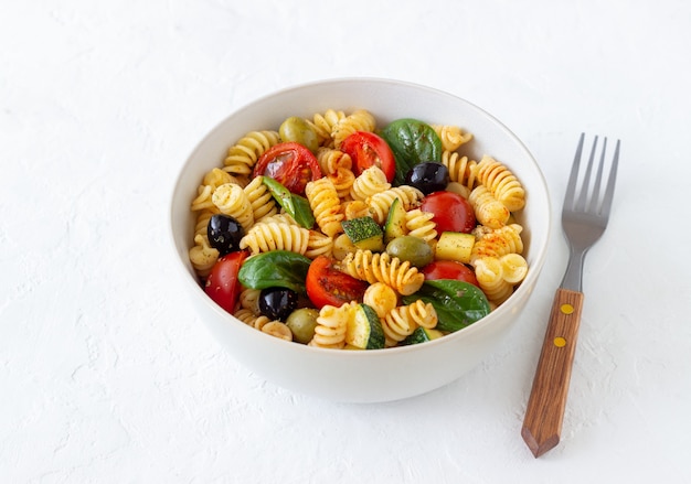 Pastasalade met tomaten, courgette, olijven en spinazie. Gezond eten. Vegetarisch eten.