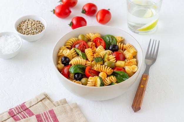 Pastasalade met tomaten, courgette, olijven en spinazie. Gezond eten. Vegetarisch eten.