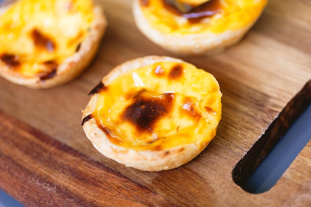 사진 먹을 준비가 된 나무 판자에 있는 pasteis de belém 또는 pasteis de nata