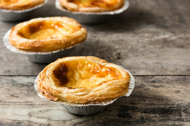 "Pasteis de nata". Typical Portuguese egg custard tart on wooden surface