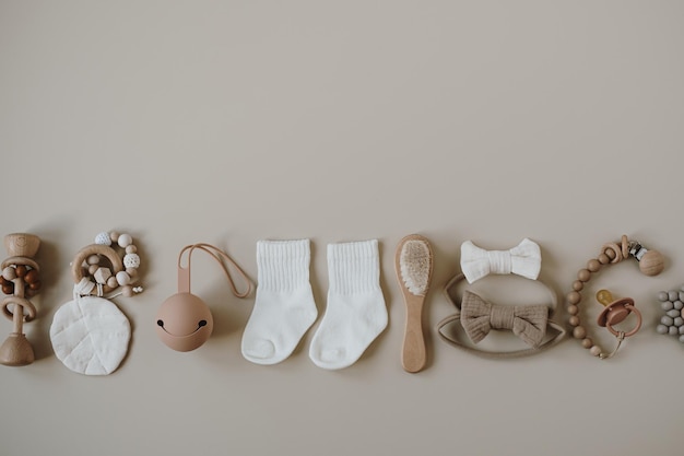 Pastel beige cozy eco friendly stylish Scandinavian newborn baby care accessories Online fashion store online shopping branding concept Brush pacifier socks bow pacifier holder on neutral beige