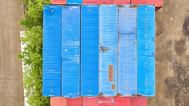 Pastel blue shipping containers like chalk in overhead aerial of shipping yard