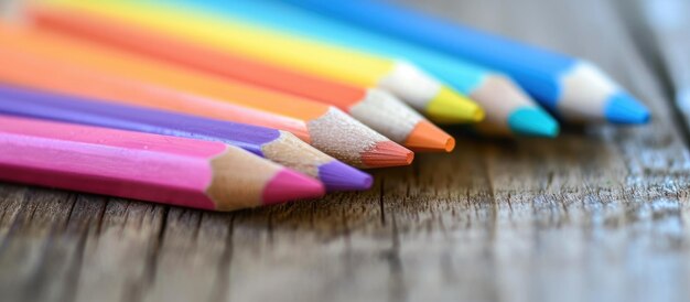 木製の机の上にあるパステル色の筆は,教育や学校の目的のためにオープンハウスのメッセージを伝えます