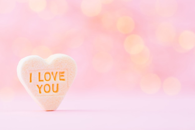 Pastel colored candy hearts in a bokeh background