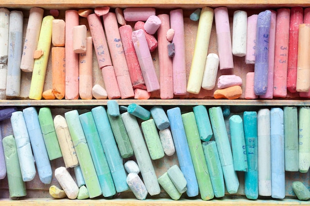 Pastel crayons in wooden artistic box closeup top view