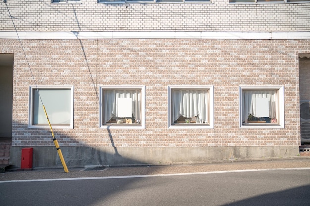 Pastel creamy brick wall with window and curtain in Japan