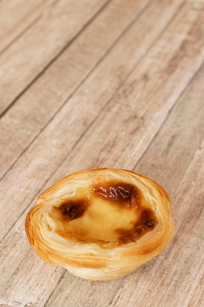 Photo pastel de nata or pastel de belem from portugal sweet on a wooden table with a vertical format for social media