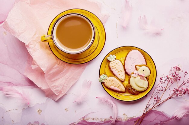 Pastel Easter background cute glazed cookies and coffee flat lay Spring card with baked symbols of Easter on pink background