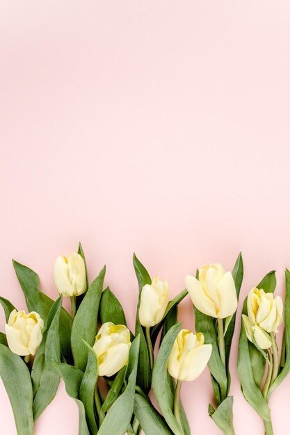 Pastel en gele tulpenbloemen boeket op roze achtergrond Platte lay top view Valentines achtergrond Bloempatroon