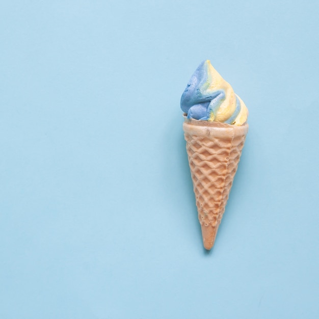 Pastel meringue cone on blue background