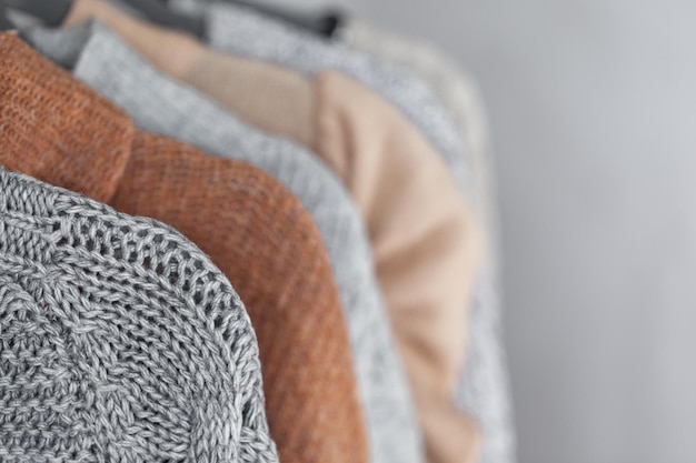 Пастельный теплый вязаный свитер висит в шкафу Уютный осенне-зимний гардероб