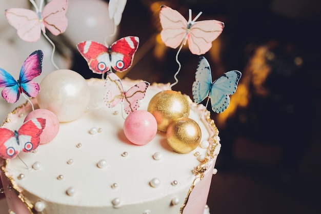 Pastelkleuren smakelijke taart met vlinder Wit geel roze en blauw crème vla Witte achtergrond Selectieve aandacht