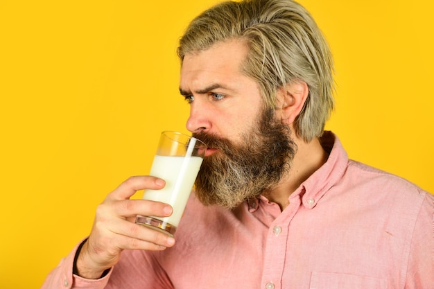 Pasteurized milk Emotional bearded man hold glass of milk Vegan milk concept Vegan milks made from wide variety of beans nut seeds and grains Healthy food Drink protein cocktail Lactose free