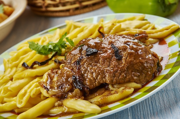Pasticada, gestoofd rundvleesgerecht gekookt in speciale saus, populair in Kroatië. Balkan keuken, traditionele geassorteerde gerechten, bovenaanzicht.