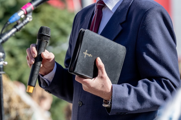 Photo pastor with a bible in his hand during a sermon. the preacher delivers a speech