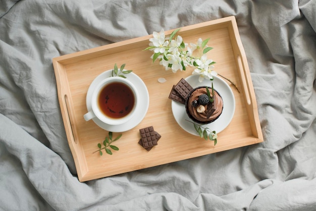 Pastries and a cup with a drink on a wooden tray