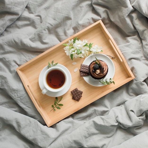 Pastries and a cup with a drink on a wooden tray