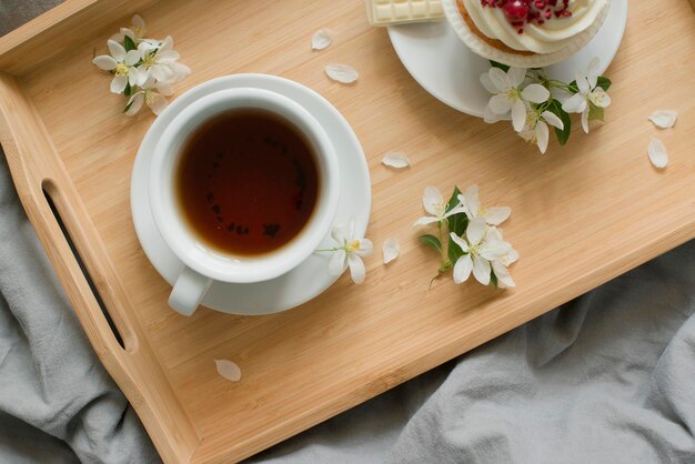 Pastries and a cup with a drink on a wooden tray