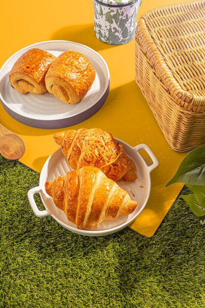 Photo pastries on a yellow background with picnic basket