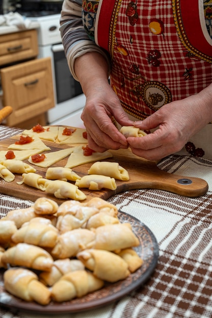 Pastry and baking concept.  Woman preparing homemade rolls with jam at home