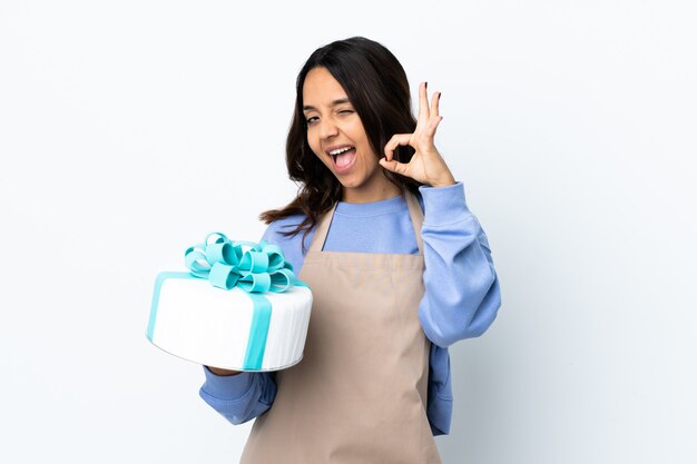 Pastry chef holding a big cake isolated