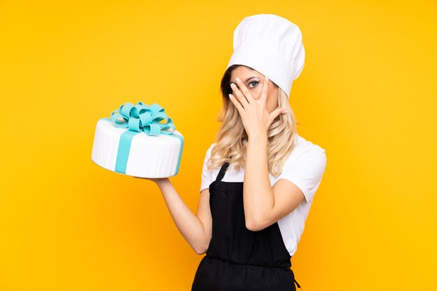 Pastry chef holding a big cake