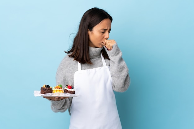 Pastry chef holding a plate with cakes