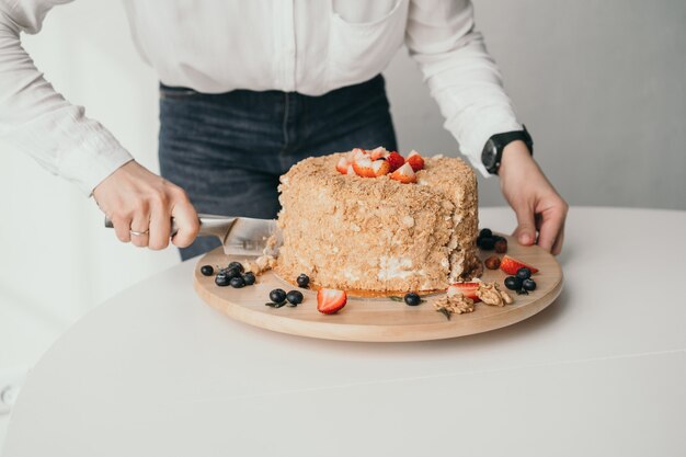 ペストリー シェフがケーキを切っています。おいしいハニー ケーキがナイフでカットされています。ハニー ケーキのクローズ アップ