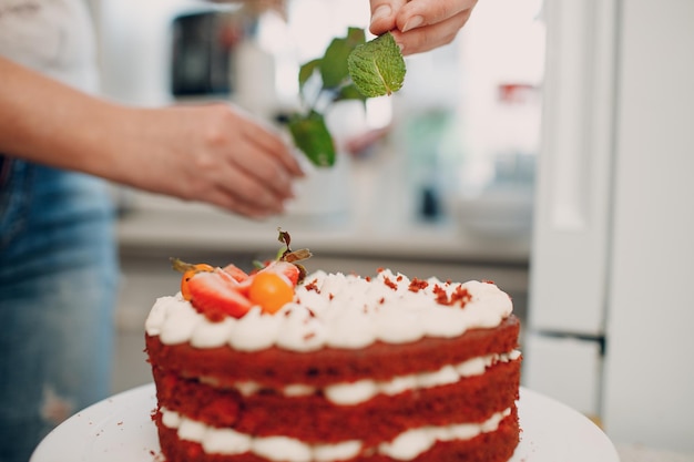 사진 패스트리 셰프가 맛있는 레드 벨벳 케이크를 만듭니다. 디저트 요리 및 장식.