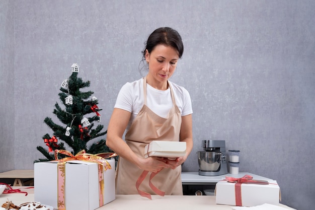 과자 요리사는 달콤한 선물을 선물 상자에 포장합니다.