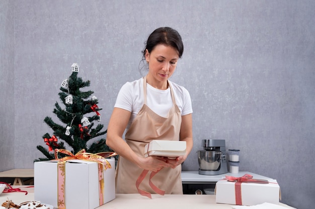 Pastry chef packs sweet gifts into gift boxes.