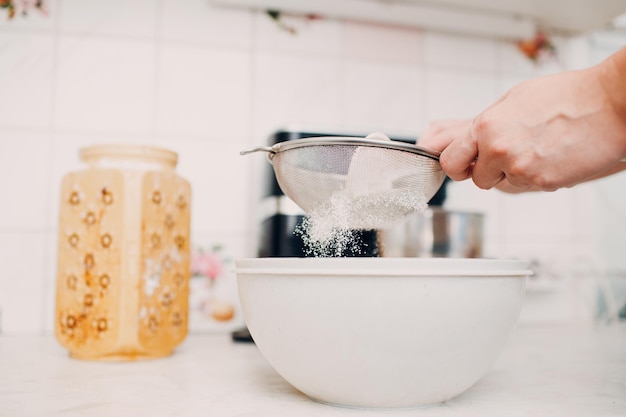 Pastry chef sift pours flour makes cake Cooking and preparing dessert