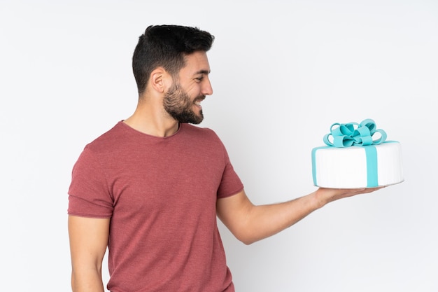 Pastry chef with a big cake on white with happy expression