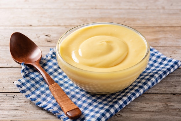 Pastry cream in a bowl on wooden table