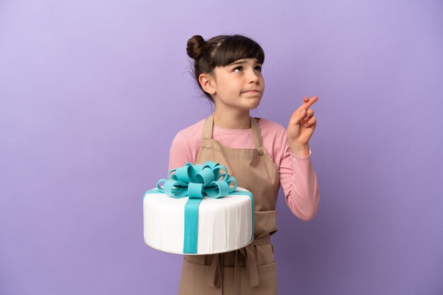 Pastry little girl holding a big cake isolated