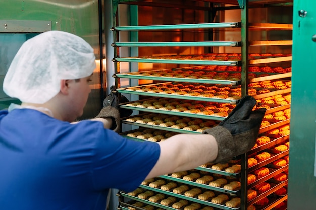 Pastry man takes out of the oven ready-made Shortbread Cookies.