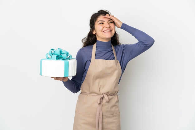 Pastry Russian chef holding a big cake isolated on white background smiling a lot