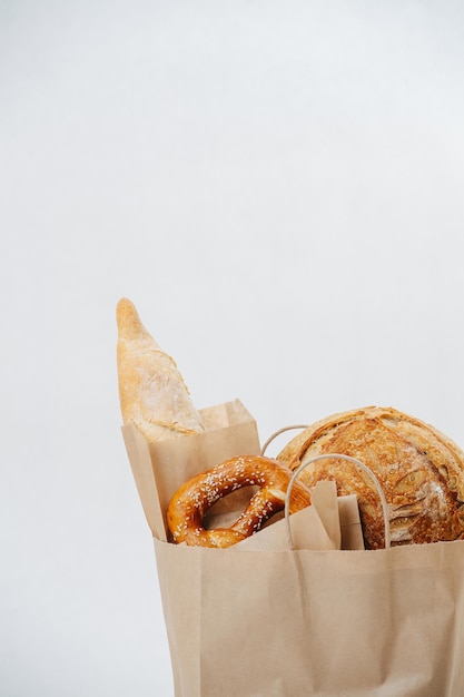 Pastry sticking out of a paper brown bag. over white background.