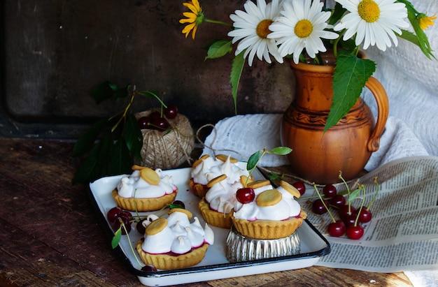 Photo pastry tartlets with meringue and cherry