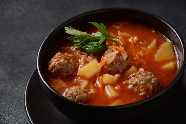 Patatesli Sulu Kofte - Turkish soup with meatballs in black bowl