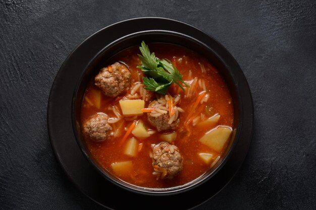 Patatesli Sulu Kofte - Turkish soup with meatballs in black bowl