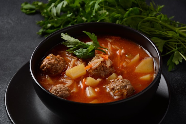 Patatesli Sulu Kofte - Turkish soup with meatballs in black bowl