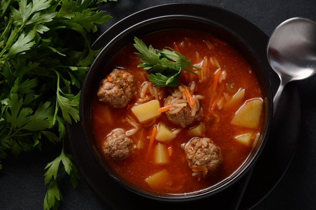 Patatesli Sulu Kofte - Turkish soup with meatballs in black bowl