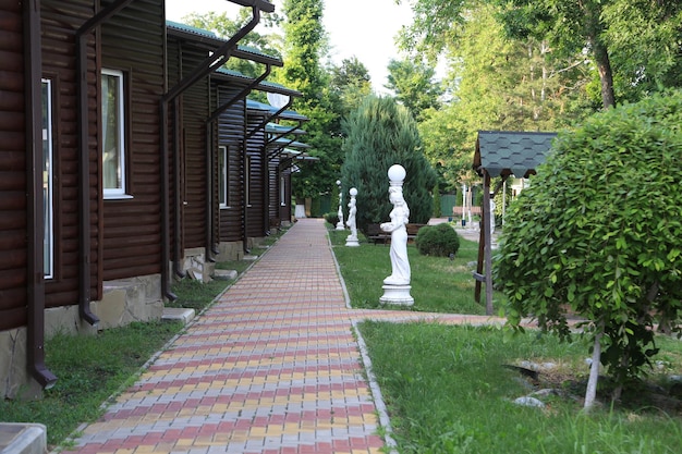 A path with a brick walkway and a row of houses with statues on it.