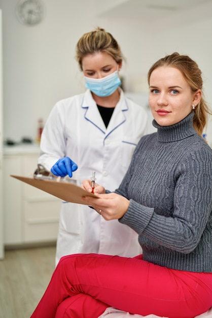 Patient in aesthetics clinic signs document