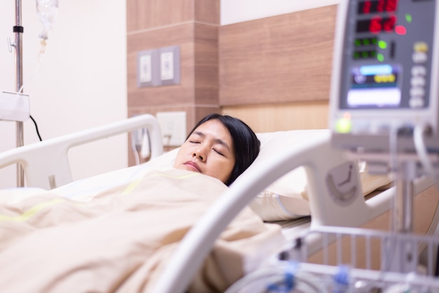 Patient Asian women sleeping under blanket on sick bed at the hospital