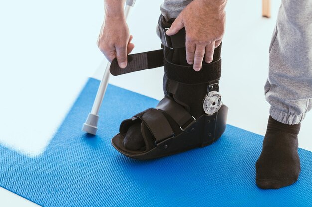 Patient in a black leg brace in a physiotherapy office