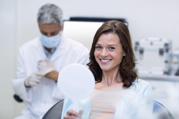 Patient checking her teeth in mirror