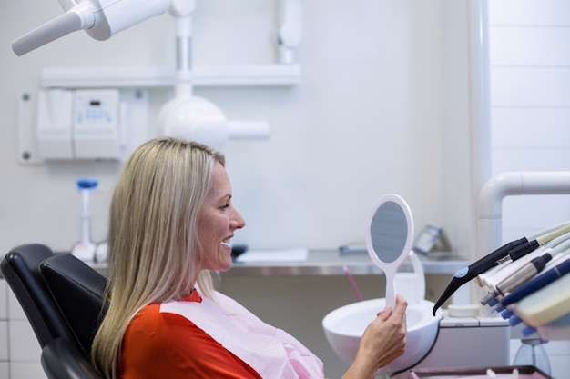 patient checking her teeth in mirror