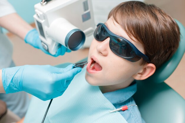 patient in dental chair teen boy having dental treatment dentist takes jaw xray